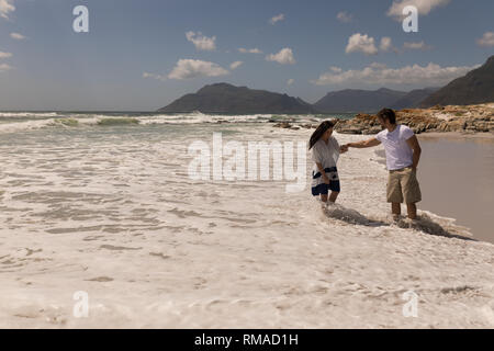 Young couple holding hands and having fun at beach Stock Photo