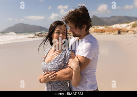 Romantic happy young couple embracing on beach Stock Photo