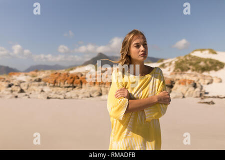 Thoughtful young woman walking on beach Stock Photo