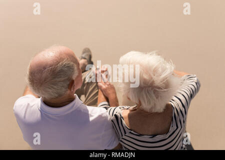 High angle view of romantic senior couple sitting on beach Stock Photo