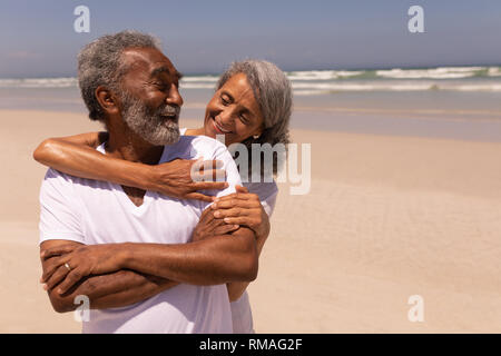 Senior woman embracing senior man on beach Stock Photo