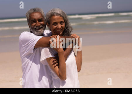 Senior man embracing senior woman on beach Stock Photo