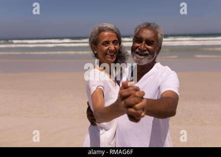Senior couple dancing together on beach Stock Photo