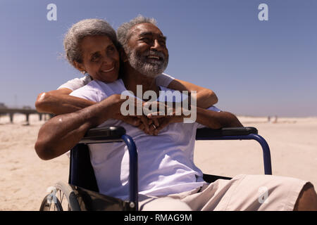 Woman embracing disabled senior man on beach Stock Photo