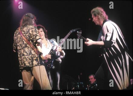 Musicians Steve Howe, Trevor Rabin and Chris Squire of the progressive rock band Yes are shown performing on stage during a 'live' concert appearance. Stock Photo