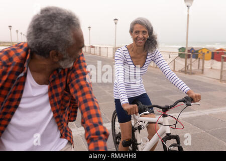 Senior couple with bicycle looking each other on promenade Stock Photo