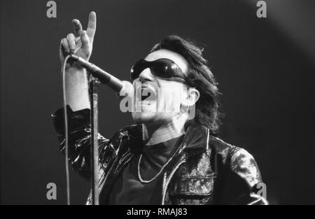 Singer Paul Hewson also, best known by his stage name Bono, of the Irish rock band U2, is shown performing on stage during a 'live' concert appearance. Stock Photo