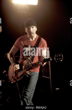 Guitarist David Evans, more widely known by his nickname and stage name The Edge, of the Irish rock band U2, is shown performing on stage during a 'live' concert appearance. Stock Photo