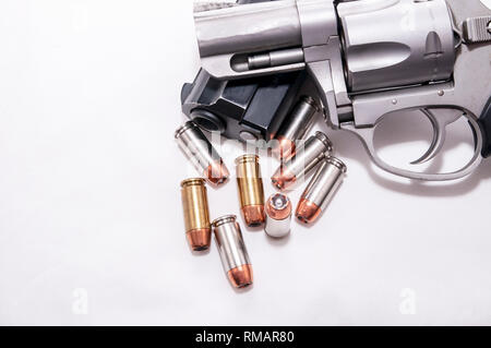 Two handguns, a 40 caliber pistol and a 357 magnum revolver with 40 caliber bullets on a white background Stock Photo