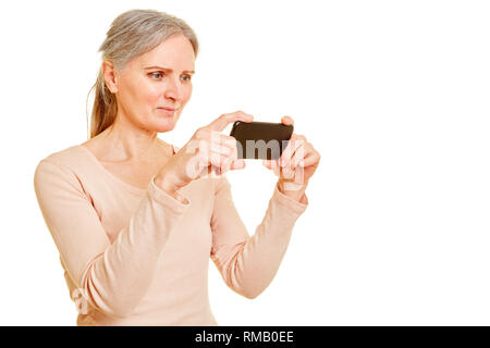 Old woman while photographing with her smartphone Stock Photo