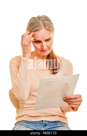 Worried senior with bill or reminder as a letter in her hands Stock Photo