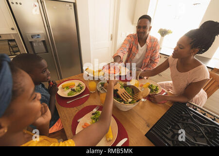 Happy African American family having food at dining table Stock Photo