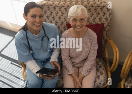 High angle view of female doctor and senior woman looking at camera Stock Photo