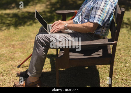 Senior man using laptop in the park Stock Photo