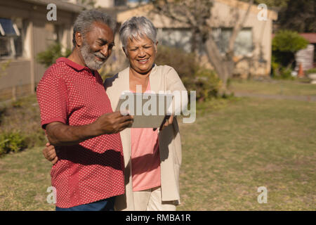 Senior couple using digital tablet in the park Stock Photo