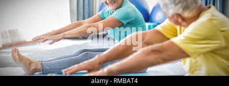 Seniors stretching legs Stock Photo