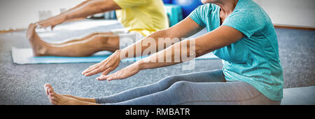 Seniors stretching legs Stock Photo