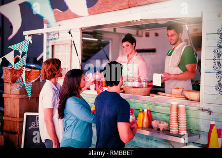 Smiling waiter taking order from customer Stock Photo