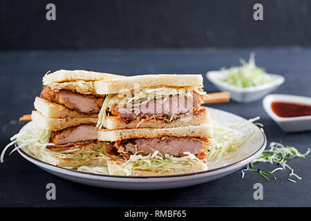 Katsu Sando - food trend japanese sandwich with breaded pork chop, cabbage and tonkatsu sauce. Japanese cuisine. Stock Photo