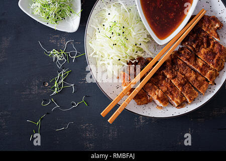 Japanese cuisine. Deep-fried pork chop, or Japanese chop with cabbage and tonkatsu sauce. Top view Stock Photo