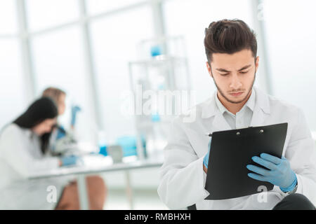 close up. a scientist doing writes the results of an experiment to a laboratory journal Stock Photo