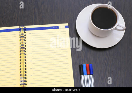 Open diary, planner and markers. Espresso coffee on an old wooden table Stock Photo