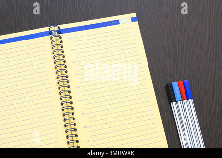 Open diary, planner and a set of markers on a close-up table Stock Photo
