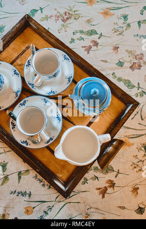 A vintage table cloth with a tea set on a wooden tray interior detail in a country house Stock Photo