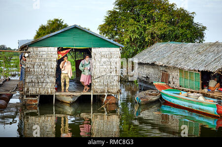 Tonlé Sap Lake,  Cambodia. 19th December, 2017. Two men stand in the opening of their floating home drinking tea in the morning. Photo: Bryan Watt Stock Photo