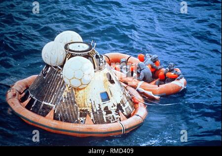 Navy divers salvage the command module of Apollo 11 with a dinghy after landing in the Pacific. Apollo 11 was the first manned Moon landing mission, and with it the most significant space mission for humanity. Stock Photo