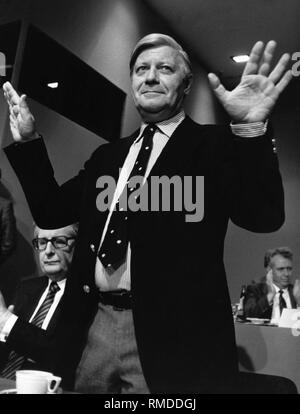 At the Federal Party Congress of the SPD, the standing former Chancellor Helmut Schmidt thanks for the applause of the delegates. To the left of him sits Hans-Jochen Vogel, parliamentary group leader of the SPD in the Bundestag. Stock Photo