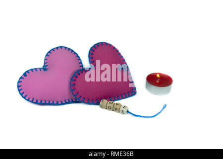 Hand stitched textile hearts with word Love on blocks threaded on strings isolated on white background for romantic relationship, Valentines Day, brok Stock Photo