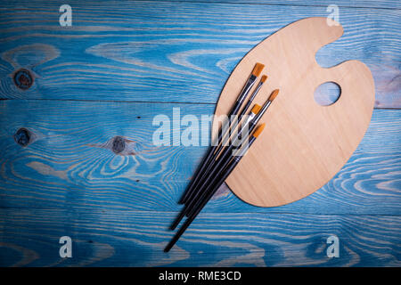 Palette and brushes on a wooden old blue background Stock Photo