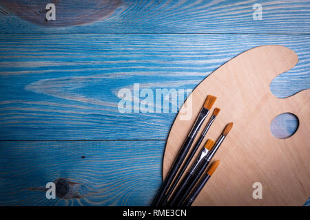 Palette and brushes on a wooden old blue background Stock Photo