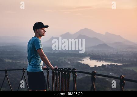 Young man contemplation at the sunset. View from Sigiriya rock in Sri Lanka. Stock Photo