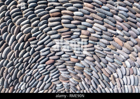 Semicircular pattern of upright placed pebble stones Stock Photo