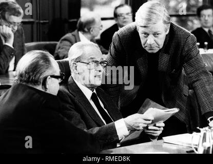 The group leader of the SPD Herbert Wehner (center) talking with Chancellor Helmut Schmidt (right) and the deputy party chairman Hans-Juergen Wischnewski (left) in the Bundestag. In the background are further deputies.