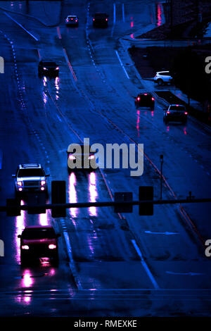 Rainstorm with cars driving in storm on roadway street lamps headlights dark Stock Photo