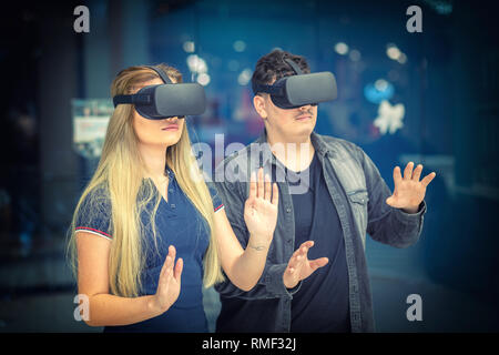 Young couple conecting with VR glasses indoor – Virtual reality concept with young woman and man having fun with headset goggles during VR experience  Stock Photo