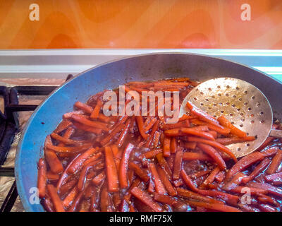 Preparation of Uzbek pilaf - roasting meat and carrots in oil, zirvak, close-up Stock Photo