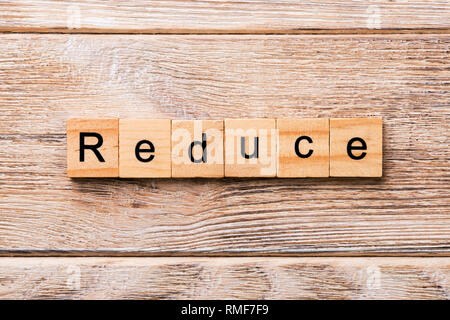 reduce word written on wood block. reduce text on wooden table for your desing, concept. Stock Photo