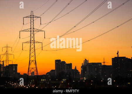 Docklands, London, UK, 14th Feb 2019. UK Weather: Following a beautifully sunny day with blue skies and mild temperatures, the sun sets over East London's Docklands, silhouetting buildings, electricity masts and shipping cranes. Credit: Imageplotter News and Sports/Alamy Live News Stock Photo