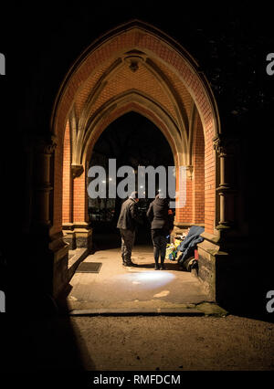 FILED - 08 February 2019, Hessen, Frankfurt/Main: 08.02.2019, Hessen, Frankfurt/Main: Elfi Ilgmann-Weiß (r) and her colleague Johannes Heuser (l) talk to a homeless man in the entrance portal of a church in the Westend, who has set up camp for the night here at single-digit temperatures. (Zu dpa ''You are angels' - Frankfurt cold bus on tour' from 13.02.2019) Photo: Boris Roessler/dpa Photo: Boris Roessler/dpa Stock Photo