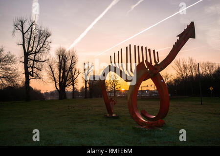 Cork City, Cork, Ireland. 15th February, 2019. Jim Buckley's sculpture Saurian, the Red Dragon stands guardian at Sunrise on the western suburbs of the city at the Lee Fields in Cork city, Ireland. Credit: David Creedon/Alamy Live News Stock Photo