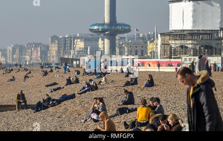 Brighton, UK. 15th Feb, 2019. Visitors enjoy the warm sunny weather on Brighton beach today as the forecast is for more of the same over the weekend Credit: Simon Dack/Alamy Live News Stock Photo