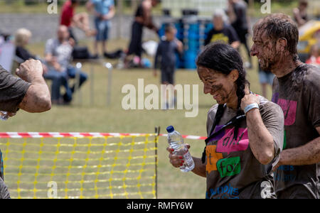 Couple covered in mud at the end of a mud run. Stock Photo