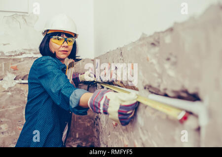 Woman working on new installations of bathroom pipes and used measuring tape - Image Stock Photo