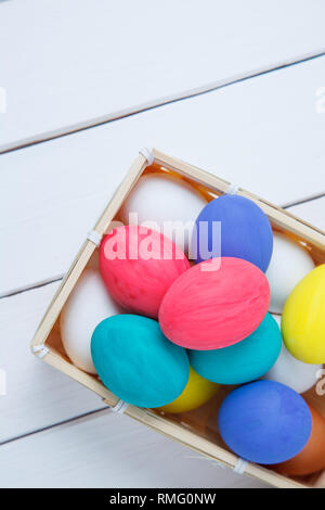 Easter, holidays, tradition and object concept - close up of colored easter eggs in basket Stock Photo