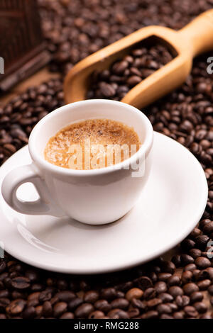 Expresso coffee cup close-up over dark roasted coffee beans Stock Photo