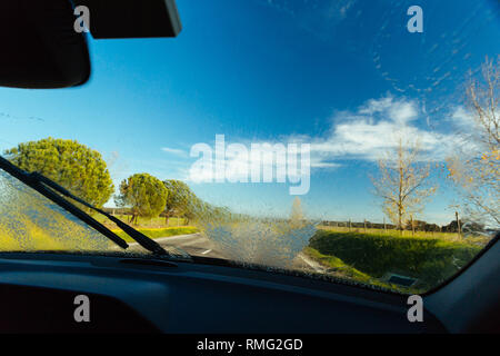 Amazing view of asphalt countryside road and majestic nature on sunny day through clean windshield of modern car Stock Photo